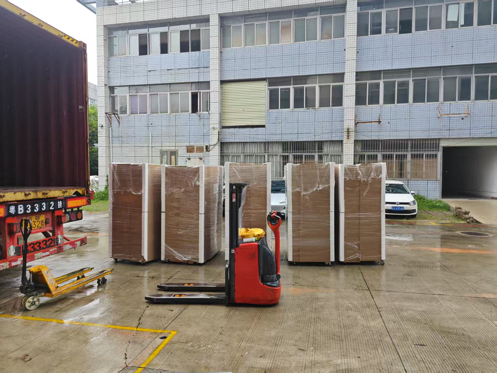 Wrapped vending machines staged beside a shipping container